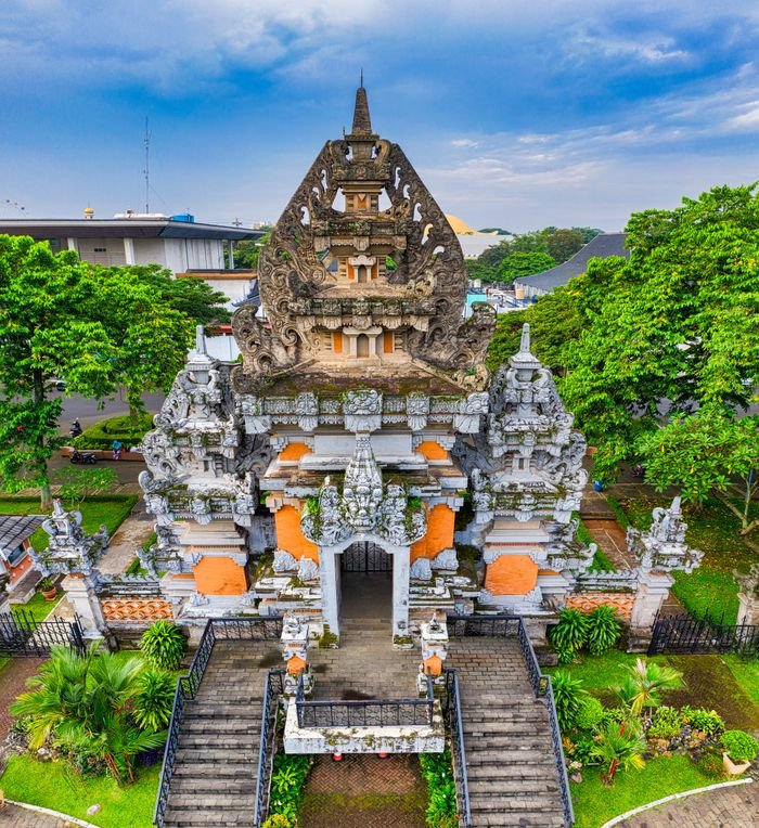 Captivating aerial shot of a traditional Balinese temple surrounded by lush greenery in Jakarta, Indonesia.