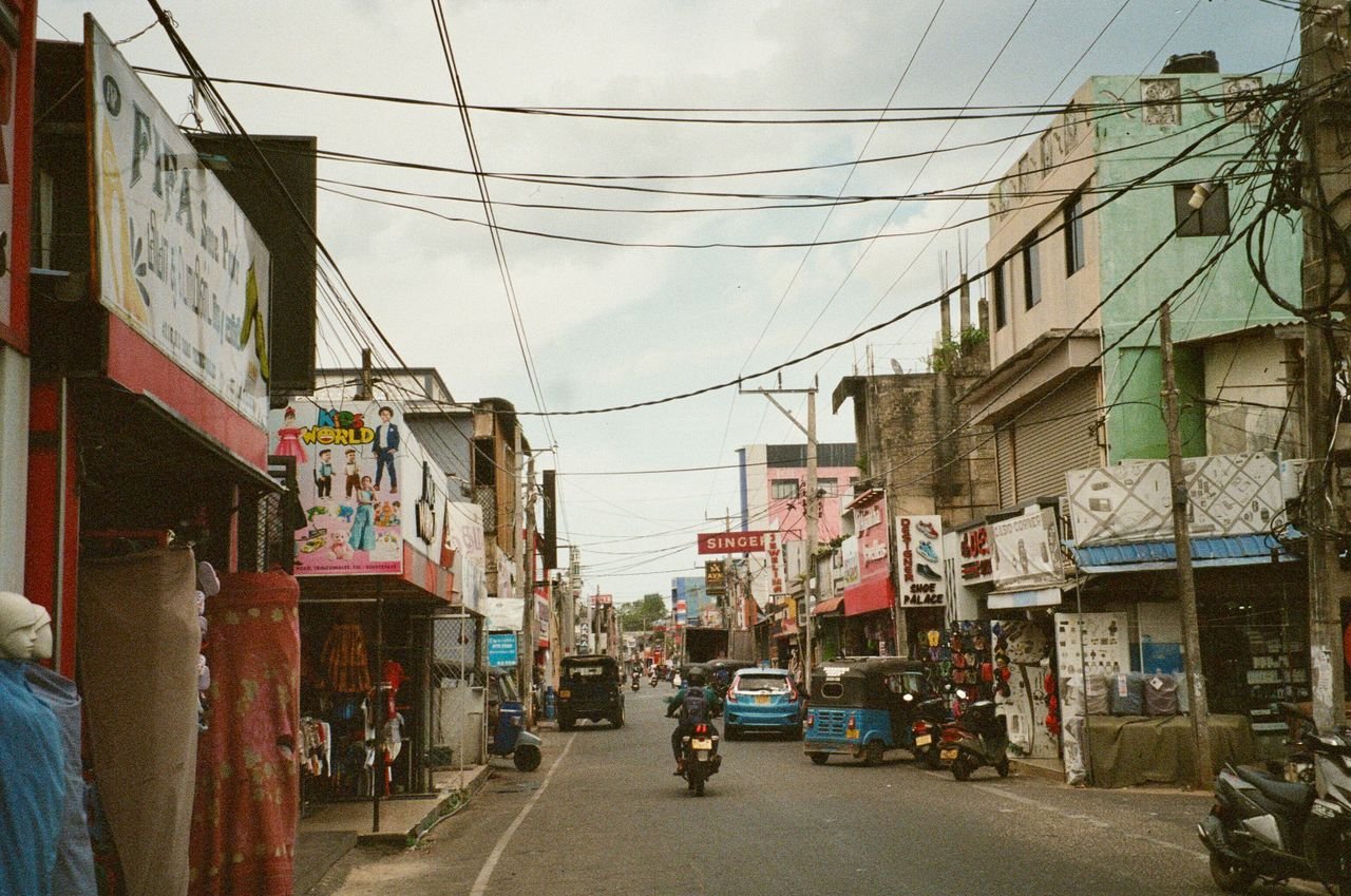 Vibrant street view showcasing daily life and local shops in Sri Lanka's urban setting.